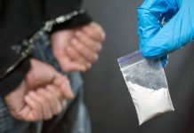 Handcuffed person and a bag of drugs