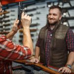 Man Showing Gun To Another Man