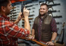 Man Showing Gun To Another Man