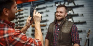 Man Showing Gun To Another Man