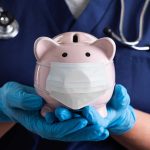 Nurse Holding A Piggy Bank