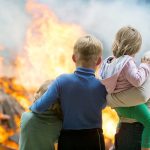 People standing in front of flames