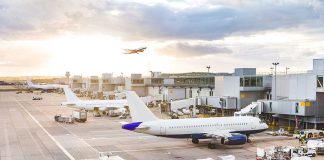 Airport with airplanes runway and terminal at sunset
