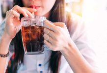 Person drinking soda from a glass mug