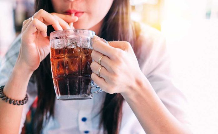 1033381774 featured image Person drinking soda from a glass mug