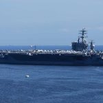 Aircraft carrier sailing on the ocean blue sky