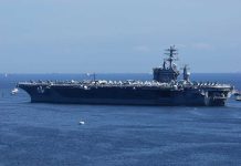 Aircraft carrier sailing on the ocean blue sky