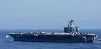 Aircraft carrier sailing on the ocean blue sky