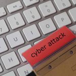 Keyboard with red folder labeled cyber attack