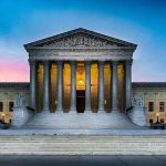 Supreme Court building with illuminated pillars and steps