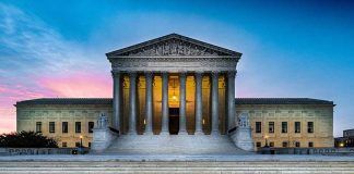 Supreme Court building with illuminated pillars and steps