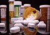 Various prescription pill bottles with scattered white tablets.
