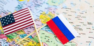 US and Russian flags on a world map