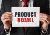 Product Recall sign held by person in suit