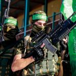 Two armed masked soldiers with green flags.