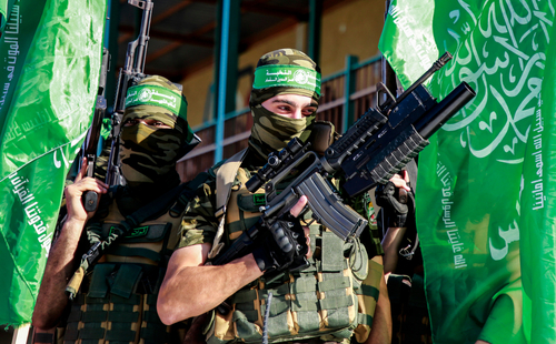 shutterstock_1979836574.jpg featured image Two armed masked soldiers with green flags.