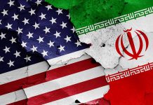 Cracked American and Iranian flags on a wall