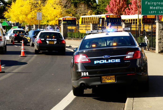 117302929 featured image Police cars and school buses on roadside with cones