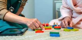 Doctor and patient playing with colorful wooden blocks
