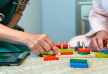 Doctor and patient playing with colorful wooden blocks