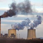 Industrial plant emitting black smoke into the sky