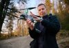 Person holding a drone in a forest