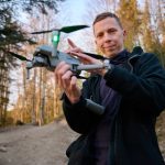 Person holding a drone in a forest