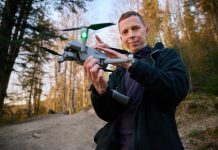 Person holding a drone in a forest