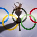 Olympic rings with a torch shadow