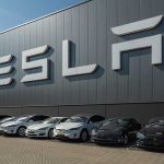 Tesla facility with parked cars in front