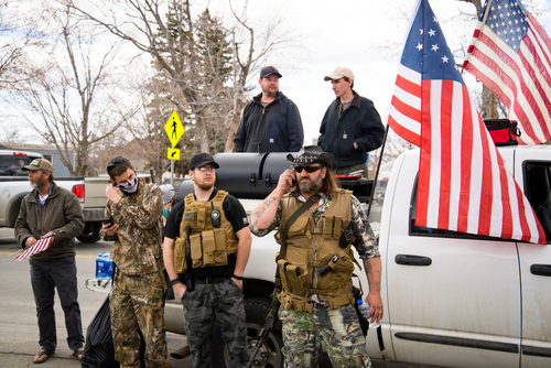 shutterstock_1715630908.jpg featured image Men in military gear with American flags near truck.