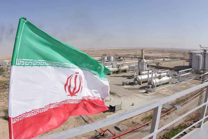 1227310843 Iranian flag near an industrial gas refinery