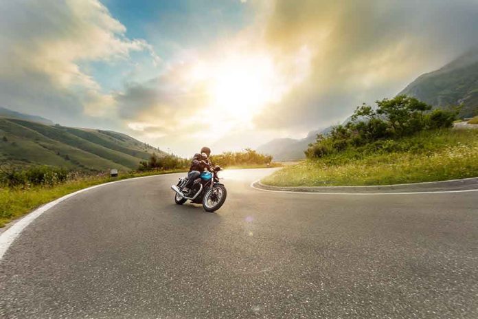 1479161540 featured image Person rides motorcycle on curved mountain road at sunset