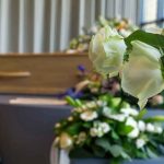 White roses in front of a casket