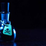 Dark bottle with skull and crossbones label on table