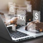 Person typing on laptop with tax-related icons displayed