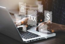 Person typing on laptop with tax-related icons displayed