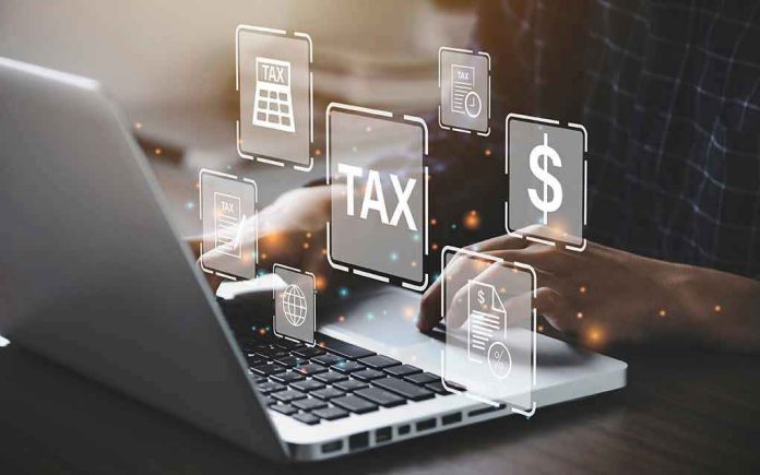 2018230646 Person typing on laptop with tax-related icons displayed