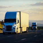 Two semitrucks driving on a highway