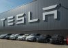Tesla facility with parked cars in front