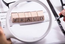 "Fraud" blocks under magnifying glass on invoices.