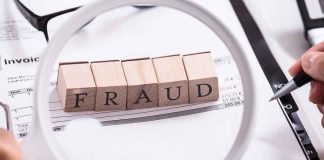 "Fraud" blocks under magnifying glass on invoices.