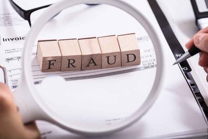 792864664 "Fraud" blocks under magnifying glass on invoices.