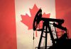 Silhouette of an oil pump jack against a Canadian flag background