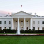The White House with fountain and American flag.
