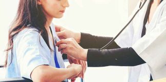 Doctor examining patient with stethoscope in hospital