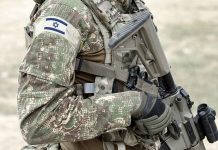 Soldier in camouflage gear with Israeli flag patch