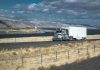 Truck driving on rural highway near river and mountains