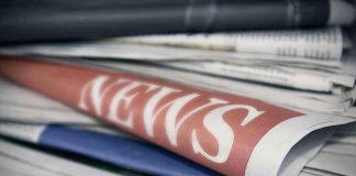 Stack of newspapers with NEWS headline visible.