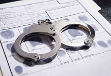 Handcuffs on fingerprint form with fingerprints visible